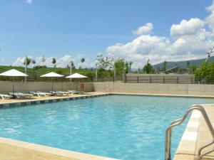 a large swimming pool with chairs and umbrellas at APARTMENTSUITESPAIN FORMIGAL ORDESa in Sabiñánigo