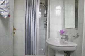 a white bathroom with a sink and a shower at Hotel La Marticana in Ischia