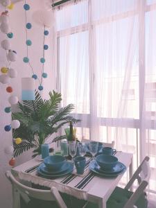 einem Tisch mit blauen Gerichten und einer Pflanze vor dem Fenster in der Unterkunft Cosy studio apartment in Torrevieja in Torrevieja