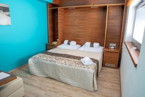 1 dormitorio con 1 cama con pared de madera en Restaurant & Design Hotel Noem Arch en Brno