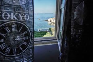 a clock in a window with a view of the ocean at Apartments Miki in Komiža