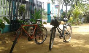 Dos motos estacionadas al lado de una cerca. en Family Nest en Dambulla