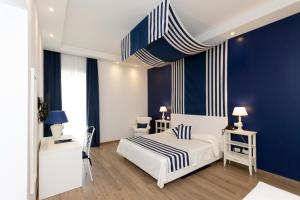 a bedroom with a white bed and blue walls at Hotel Nautilus in Cagliari