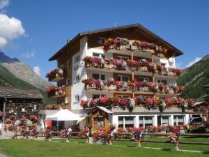a large building with flower boxes on it at B&B Haus Granit Saas Grund in Saas-Grund