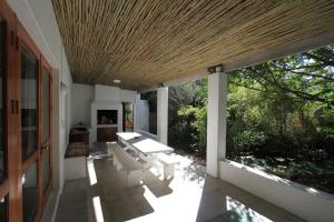 porche con sillas blancas y techo de madera en Haven of Peace and Garden Cottage en Hermanus