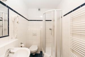 a bathroom with a toilet and a sink and a shower at Hotel Boston in Karlovy Vary
