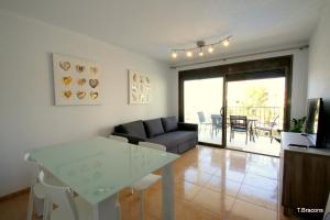 ein Wohnzimmer mit einem Tisch und einem Sofa in der Unterkunft Apartamento Mimosas in Miami Platja