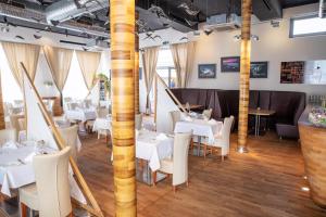 a dining room with white tables and chairs at Restaurant & Design Hotel Noem Arch in Brno