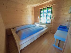 een bed in een houten kamer met een raam bij Bird View Lofoten in Bøstad