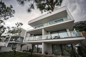a large white house with glass windows at Villa Amoretta - Pisak (Omiš) in Pisak