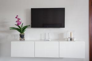 un armadio bianco con una TV su una parete bianca di Apartamento playa coqueto junto al mar a Playa Honda