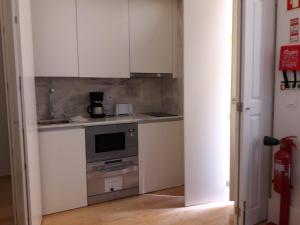 ポルトにあるCitybreak-Apartments Caldeireirosのキッチン(白いキャビネット、コンロ付)