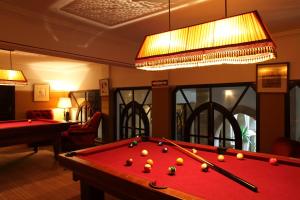 a living room with a pool table and a chandelier at Heure Bleue Palais - Relais & Châteaux in Essaouira