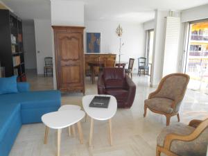 マンドリュー・ラ・ナプールにあるAppartement Le France - Vacances Côte d'Azurのリビングルーム(ソファ、テーブル、椅子付)