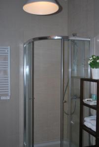 a shower with a glass door in a bathroom at Pensión Acibeche in Santiago de Compostela