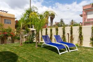 two blue chairs sitting on the grass in a yard at Hotel Nautilus in Cagliari