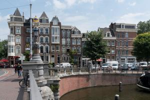 a bridge over a river in a city with buildings at City centre studio canal belt in Amsterdam