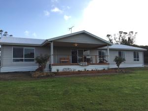 uma casa branca com um alpendre e um quintal em My Island Home em Kingscote