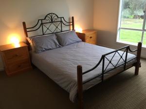 a bedroom with a large bed and two night stands at My Island Home in Kingscote