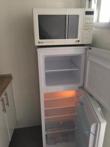 a refrigerator with a microwave on top of it at La Casa de la Higuerita in Fuengirola