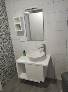 a white bathroom with a sink and a mirror at Casavó in São Roque do Pico