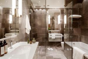 a bathroom with a tub and a toilet and a sink at Hotel St. George Helsinki in Helsinki