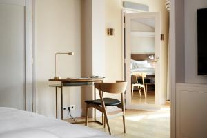 a room with a bed, chair and a table at Hotel St. George Helsinki in Helsinki