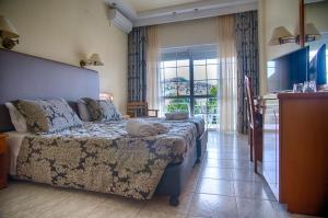 a bedroom with a bed and a large window at Hotel Diamantidis in Myrina