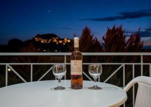 a bottle of wine sitting on a table with two wine glasses at Hotel Diamantidis in Myrina