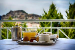 a tray of breakfast food and orange juice on a table at Hotel Diamantidis in Myrina