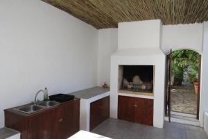 cocina con fregadero y chimenea en Haven of Peace and Garden Cottage en Hermanus