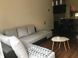 a living room with a couch and a table at Candy Apartman in Keszthely