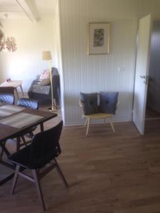 ein Wohnzimmer mit einem Tisch, Stühlen und einem Bett in der Unterkunft Malenes Ferieleiligheter in Rauland