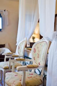 duas cadeiras num quarto com cortinas brancas em Torre Palombara - Dimora Storica em Narni