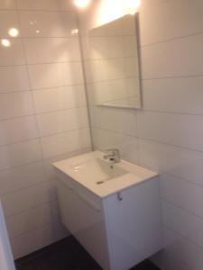 uma casa de banho branca com um lavatório e um espelho em Malenes Ferieleiligheter em Rauland