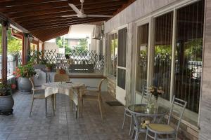 a screened in porch with a table and chairs at Villa Fallias in Olympic Beach