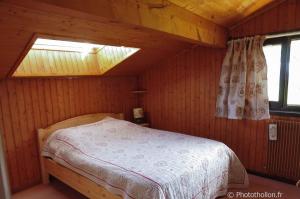 トロンにある2 pièces Les Iris 20 Station Thollon les Mémisesの木造キャビン内のベッド1台が備わるベッドルーム1室を利用します。
