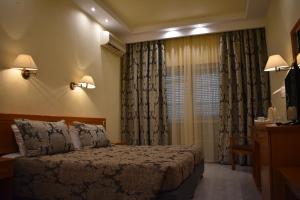 a hotel room with a bed and a window at Hotel Diamantidis in Myrina