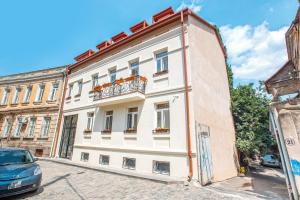 a large white building with a balcony on a street at Le Caucase in Tbilisi City