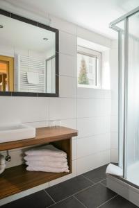 ein Bad mit einem Waschbecken und einem Spiegel in der Unterkunft Alpenpension Regina in Nauders