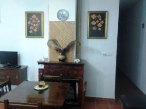 a dining room with a table and a fan on the wall at Hostal Rural Venta La Vega in Ronda