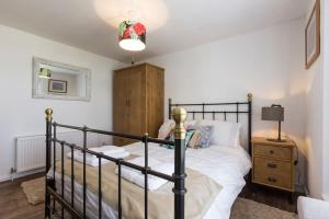 a bedroom with a black bed and a night stand at Marine Cottage in Whitstable