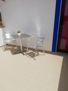 a table with two chairs and a table with a plant on it at Sol Mar in Odeceixe