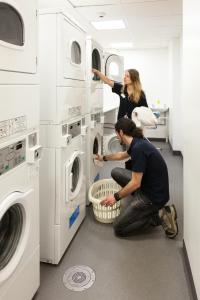 two women in a laundry room with machines at Edinburgh Central Accommodation in Edinburgh