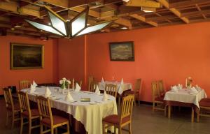 a dining room with tables and chairs and a chandelier at Motel Brencis in Iecava