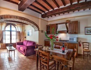 sala de estar con mesa y sofá púrpura en Agriturismo Sanguineto, en Acquaviva