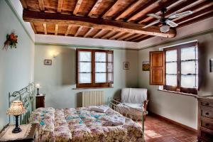 una camera con letto e ventilatore a soffitto di Agriturismo Sanguineto ad Acquaviva