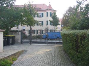 une clôture devant une maison avec une camionnette bleue dans l'établissement Wasserwerk Trachau, à Dresde