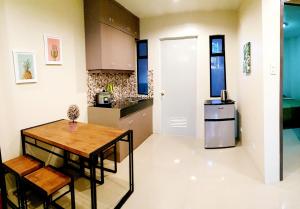 eine Küche mit einem Holztisch und einem Kühlschrank in der Unterkunft Mailz Haven 7-2BR Apartment in Davao City