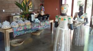 two mannequins in a room with a table with food at Villas Pratagy Resort in Maceió +97 photos